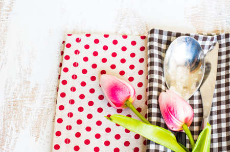 spring rusty table settings with fresh tulips, napkin and silverware