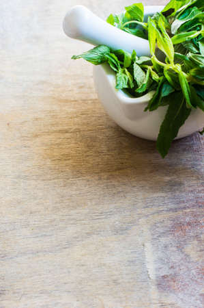 mortar with fresh mint on rustic backgroundの写真素材