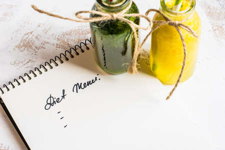 Vintage style bottles with fresh organic orange and green spinach smoothie on wooden table