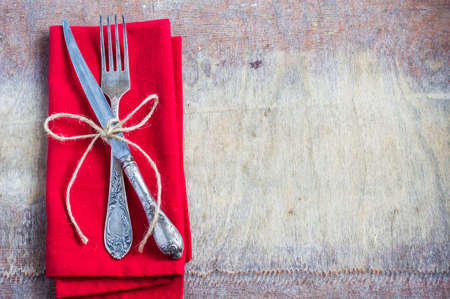 Rustic table setting with bright napkin and  silverware on old wooden table. View from above with copy spaceの写真素材