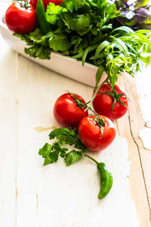 Fresh organic vegetables like a tomatoes, cucumer, green peper,  spinach and parsley on rustic wooden backgroundの写真素材
