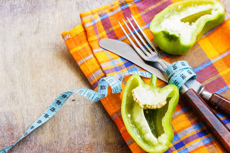 Diet concept with fresh bell pepper, silverware and measure tapeの写真素材