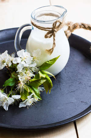 Old fashioned jar of milk on napkin on rustic wooden table.の写真素材