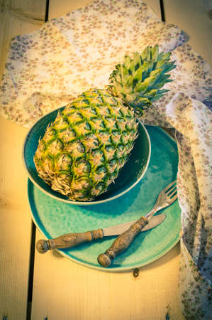 Fresh ananas fruit on vintage style plate. Toned imageの写真素材