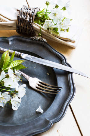 Spring time table setting with rustic plates and cherry blossom