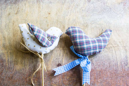 Couple of textile birds on rustic wooden backgroundの写真素材