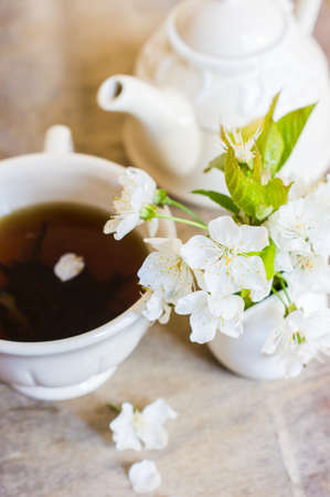 Cup of tea and cherry blossom on rustic tableの写真素材