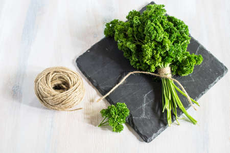 Fresh parsley herb as a cooking concept on the old wooden table