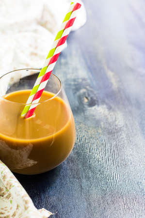 Glass of coffee with milk and coffee beans on rustic wooden table, Selective focus