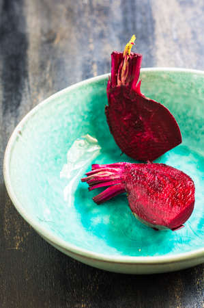 Fresh organic beet vegetable on vintage plate on rustic wooden backgroundの写真素材