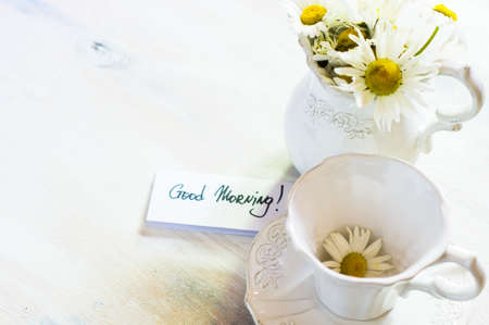 Rusric table setting with vintage silverware and plates and wild daisy flowers on vintage wooden tableの写真素材