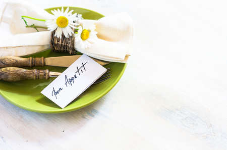 Rusric table setting with vintage silverware and plates and wild daisy flowers on vintage wooden tableの写真素材