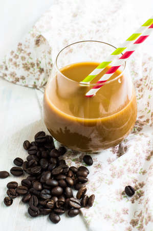 Glass of coffee with milk and coffee beans on rustic wooden table, Selective focus