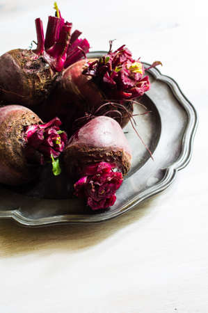 Fresh organic beet vegetable on vintage plate on rustic wooden background