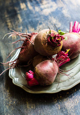 Fresh organic beet vegetable on vintage plate on rustic wooden background