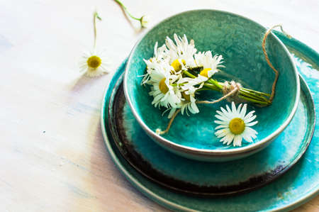 Rusric table setting with vintage silverware and plates and wild daisy flowers on vintage wooden tableの写真素材
