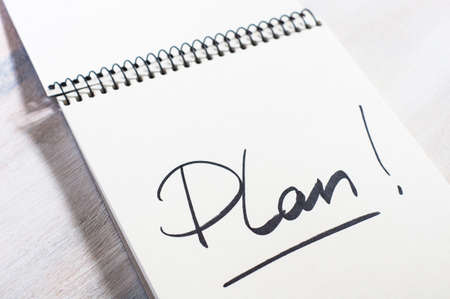 Notebook with an action plan and sticker today on wooden deskの写真素材