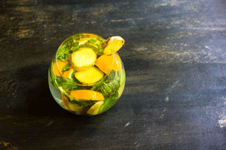 Cup of tea with ginger, mint, lemon, cinnamon sticks and anise star spice on the rustic backgroundの写真素材