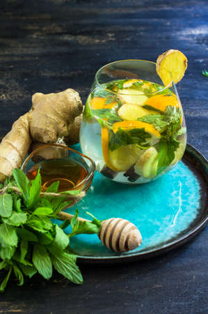 Cup of tea with ginger, mint, lemon, cinnamon sticks and anise star spice on the rustic backgroundの写真素材