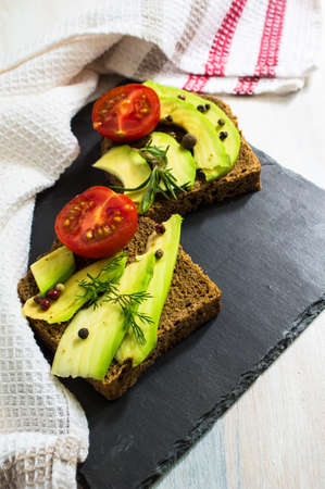 Bruschetta with tomato, avocado, chilli peper and herbsの写真素材