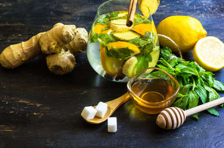 Cup of tea with ginger, mint, lemon, cinnamon sticks and anise star spice on the rustic backgroundの写真素材