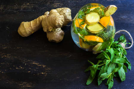 Cup of tea with ginger, mint, lemon, cinnamon sticks and anise star spice on the rustic backgroundの写真素材
