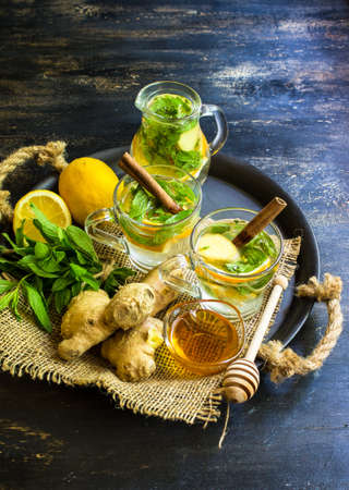 Cup of tea with ginger, mint, lemon, cinnamon sticks and anise star spice on the rustic background