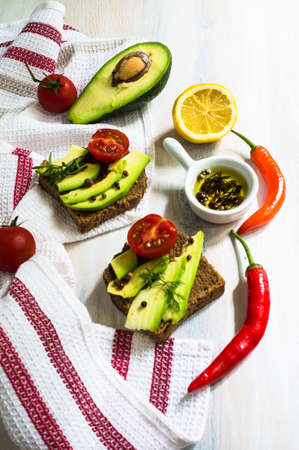 Bruschetta with tomato, avocado, chilli peper and herbsの写真素材