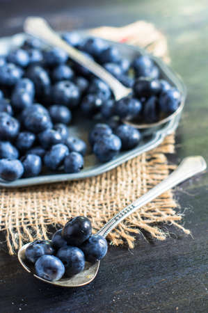 Fresh organic bilberry fruits on rustic kitchen tableの写真素材