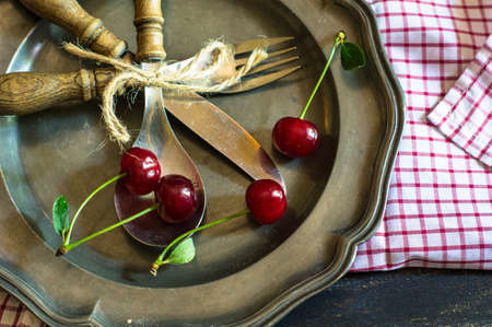 Fresh cherry berries on rustic wooden table and vintage background