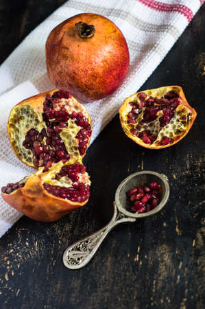 Fresh pomegranate fruit on vintage plate on rustic wooden table