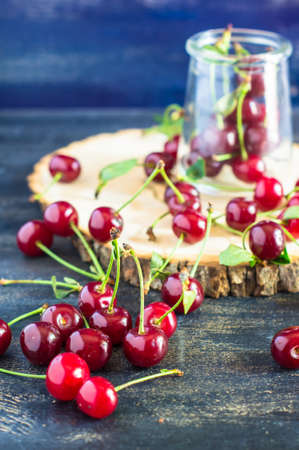 Fresh cherry berries on rustic wooden table and vintage background