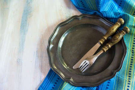 Table setting with vintage porcelain plates and silverware on rustic wooden table