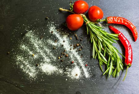 Cooking concept with fresh rosemary and spices on rustic background