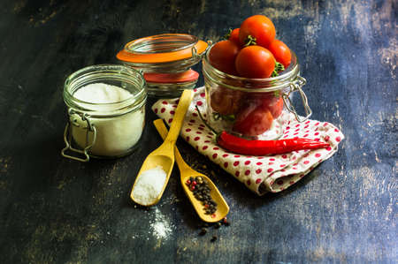 Cooking concept with fresh cherry toatoes, pepper grain, salt and straw on rustic wooden backgroundの写真素材