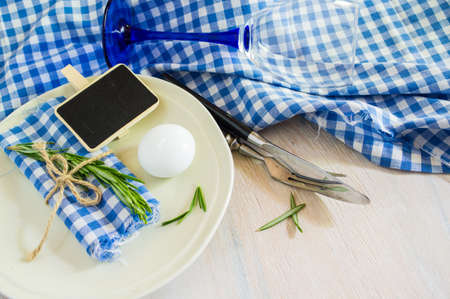 Summertime table setting with fresh rosemary on rustic wooden table
