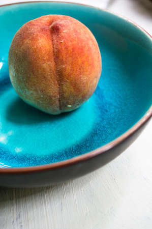 Vintage plates and fresh organoc peach fruits on rustic backgroundの写真素材
