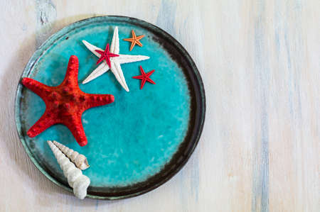 Marine table setting with sea stars and vintage tableware on rustic wooden backgroundの写真素材