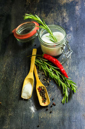 Cooking concept with fresh rosemary and spices on rustic backgroundの写真素材