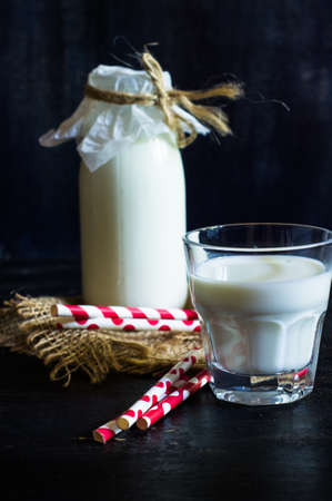 Vintage glass bottle with organic milk on rustic wooden tableの写真素材
