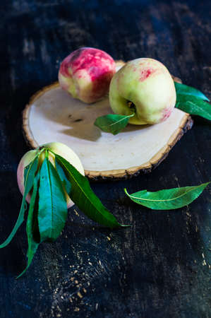 Fresh organic peach fruits just harvested on the rustic wooden tableの写真素材