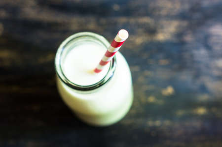 Vintage glass bottle with organic milk on rustic wooden tableの写真素材