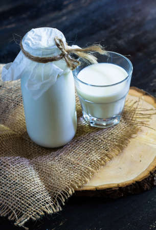 Vintage glass bottle with organic milk on rustic wooden tableの写真素材
