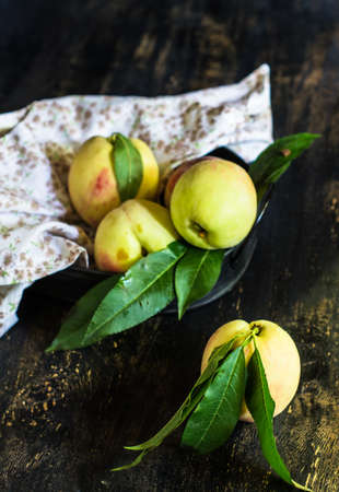 Fresh organic peach fruits just harvested on the rustic wooden tableの写真素材