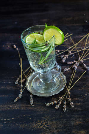 Detox beverage with fresh lime and rosemary on rustic backgroundの写真素材
