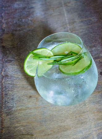 Detox beverage with fresh lime and rosemary on rustic backgroundの写真素材
