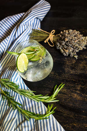 Detox beverage with fresh lime and rosemary on rustic backgroundの写真素材