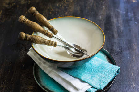 Rustic table setting with vintage silverware ad plates on old styled napkinsの写真素材