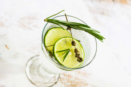 Detox beverage with fresh lime and rosemary on rustic backgroundの写真素材