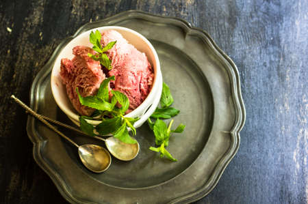 Fruit ice cream with fresh mint on rustic tableの写真素材
